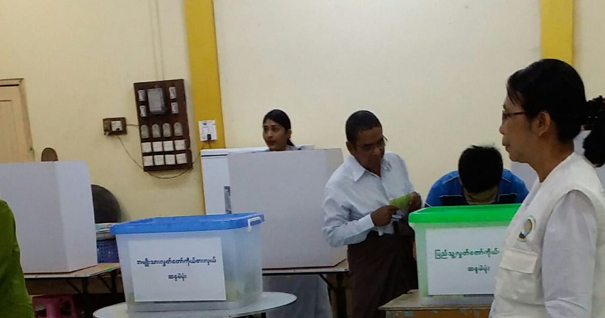Urna eletrônica de votação e cabine eleitoral em primeiro plano